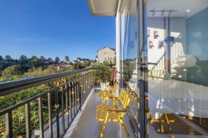 a balcony with chairs and a view of a building at Happy Home in Da Thanh +8 photos