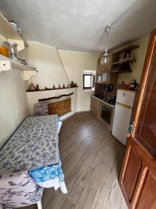 a small kitchen with a table and a refrigerator at In Our Garden Sardinia La Casina Rurale CIN3323 in Capitana