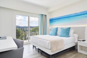 a bedroom with a bed and a large window at Invisa Hotel Es Pla - Adults Only in San Antonio