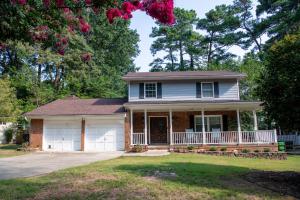a house with a porch and a garage at Spacious 4BR House Sleeps 9 Outdoor Lounge with Fire Pit plus Games in Raleigh
