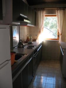 a kitchen with a stove and a sink and a window at Villa Maslina in Vantačići