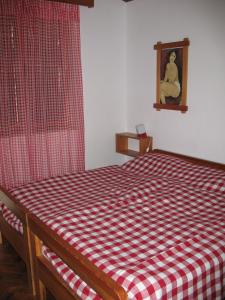 a bedroom with a red and white checkered bed at Villa Maslina in Vantačići