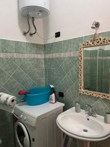 un bagno con lavandino e specchio di Casa La Pavoncella a Orosei Altre 32 foto