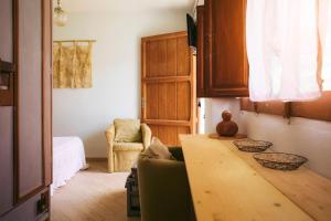 a living room with a wooden table and a chair at In Our Garden Sardinia La Casina Rurale CIN3323 in Capitana