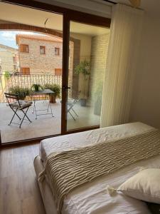 a bedroom with a bed and a view of a patio at Apartament Rural ca la Roser in Espluga de Francolí