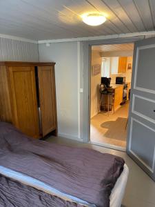 a bedroom with a bed and a dining room with a kitchen at Sjarmerende historisk leilighet midt i Tromsø in Tromsø