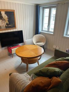 a living room with a couch and a table at Sjarmerende historisk leilighet midt i Tromsø in Tromsø