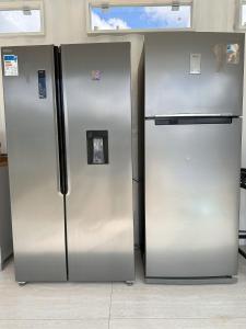 dos refrigeradores de acero inoxidable sentados uno al lado del otro en Jardim dos Sentidos no Lago Sul, en Brasilia