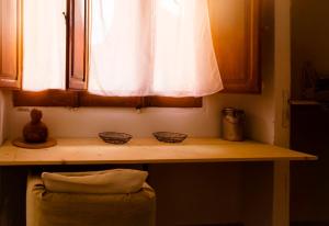 a window with two bowls on a wooden shelf at In Our Garden Sardinia La Casina Rurale CIN3323 in Capitana +10 photos