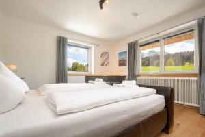 two beds in a bedroom with two windows at Grand Chalet Hochfilzen in Hochfilzen