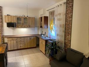 a kitchen with wooden cabinets and a couch in a room at Kleine gemütliche Wohnung in Steinhöfel