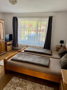 two beds in a room with a window at Casa Flamingo in Sovata