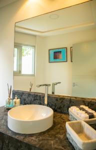 a bathroom with a large mirror and a sink at Forest House Pipa in Pipa