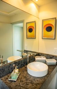 a bathroom with two sinks and a large mirror at Forest House Pipa in Pipa +26 photos