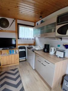 a kitchen with white cabinets and wooden ceilings at Ferienbungalow in Zirkow