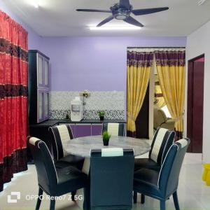 a dining room with a table and chairs at Homestay 43 Taman Sekaya in Guar Chempedak