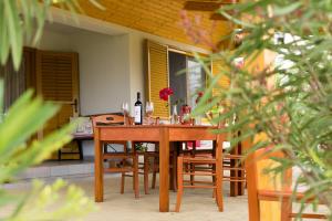 a table with chairs and a bottle of wine on a patio at Vineas vendégház in Siklós