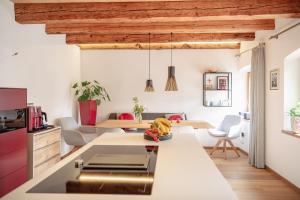 a kitchen and living room with white walls and wooden ceilings at Ferienhaus am Park in Grafenau +31 photos