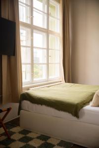 a bedroom with a bed and a large window at The Charming by Curt Suites in Berlin