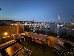 a balcony with a table and chairs and a view of a harbor at Sea Front in La Ciotat