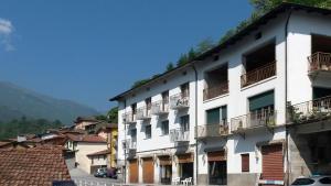 ein großes weißes Gebäude mit Balkon auf einer Straße in der Unterkunft B&B Zia Maria in Garzeno