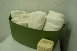a green bucket filled with towels in a bathroom at Casa Paradiso Sciacca in Sciacca +30 photos
