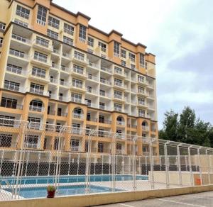a large building with a pool in front of it at Appartment 710 - Zahrat Al Khareef in Salalah