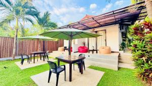a patio with tables and chairs and umbrellas at Luaya Beach in Tangalle