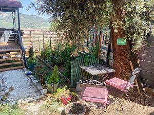 a patio with two chairs and a table next to a tree at Roulotte Lialou in Saint-Péray