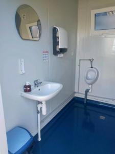 a bathroom with a sink and a urinal at Nalu Glamp in Darłowo