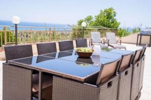 a table and chairs on a patio with the ocean in the background at Casa Paradiso Sciacca in Sciacca