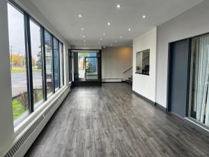 an empty office lobby with large windows and wooden floors at Motel 6 Sault Ste. Marie, ON in Sault Ste. Marie