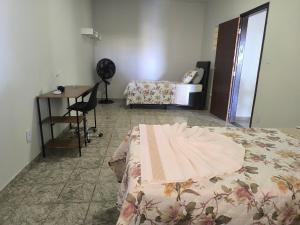 a bedroom with a bed and a table and a desk at Casa Alegria até 9 pessoas, Piscina, Churrasqueira, Empresas e Grupos in Montes Claros
