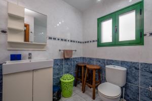 Un baño con inodoro, lavabo y ventana. en Jardin Del Sol 30, en Playa Blanca 4 fotos más