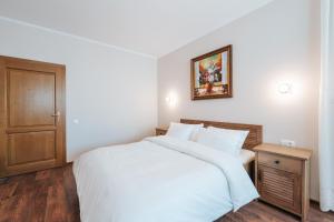 a bedroom with a white bed and a wooden door at Vila Anisoara in Predeal