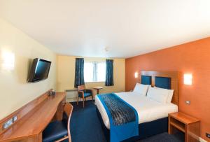 a hotel room with a bed and a television at Leonardo Inn Aberdeen Airport in Dyce