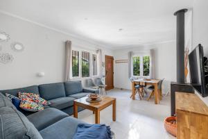 a living room with a blue couch and a table at Moraira Sweet Home with AC in Teulada