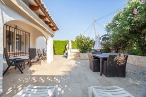 a patio with chairs and a table and an umbrella at Moraira Sweet Home with AC in Teulada
