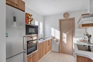 a kitchen with white appliances and wooden cabinets at Moraira Sweet Home with AC in Teulada