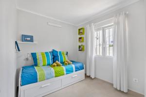 a bedroom with a bed with blue and yellow at Moraira Sweet Home with AC in Teulada +20 photos