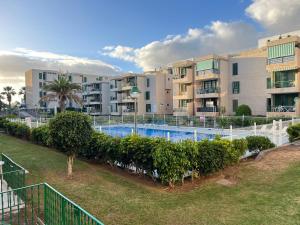 a swimming pool in front of some apartment buildings at The Cozy Palm in Playa de las Americas