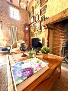 a living room with a table with a book on it at Clos César, Maison de charme rénovée 