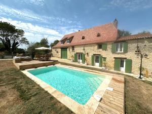 a large swimming pool in front of a house at Clos César, Maison de charme rénovée 