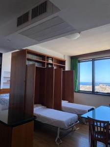 una camera con letti, tavolo e finestra di Sul Tetto di Gallipoli a Gallipoli Altre 9 foto