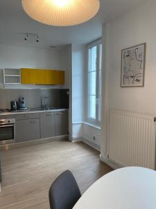 a kitchen with a table and a dining room at Appartement F2 - Besançon - proche centre ville in Besançon