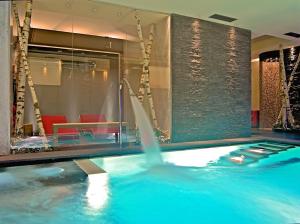 a swimming pool with a fountain in a hotel room at Hotel Avio in Temù