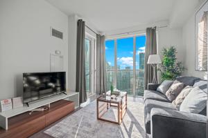 a living room with a couch and a large window at 1-Bedroom & Den condo Bird's Eye View in DT in Toronto