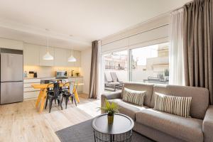 a living room with a couch and a table at Sitges Group Calm Beach in Sitges
