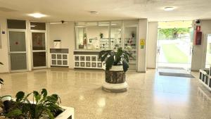 a lobby with a potted plant in the middle at Costamar Infinite Sea Views by Deihu Experiences in Los Cristianos +26 photos