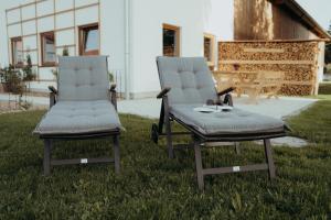 two chairs sitting next to each other in the grass at Ferienwohnung Heuboden am Eberlhof in Schechen